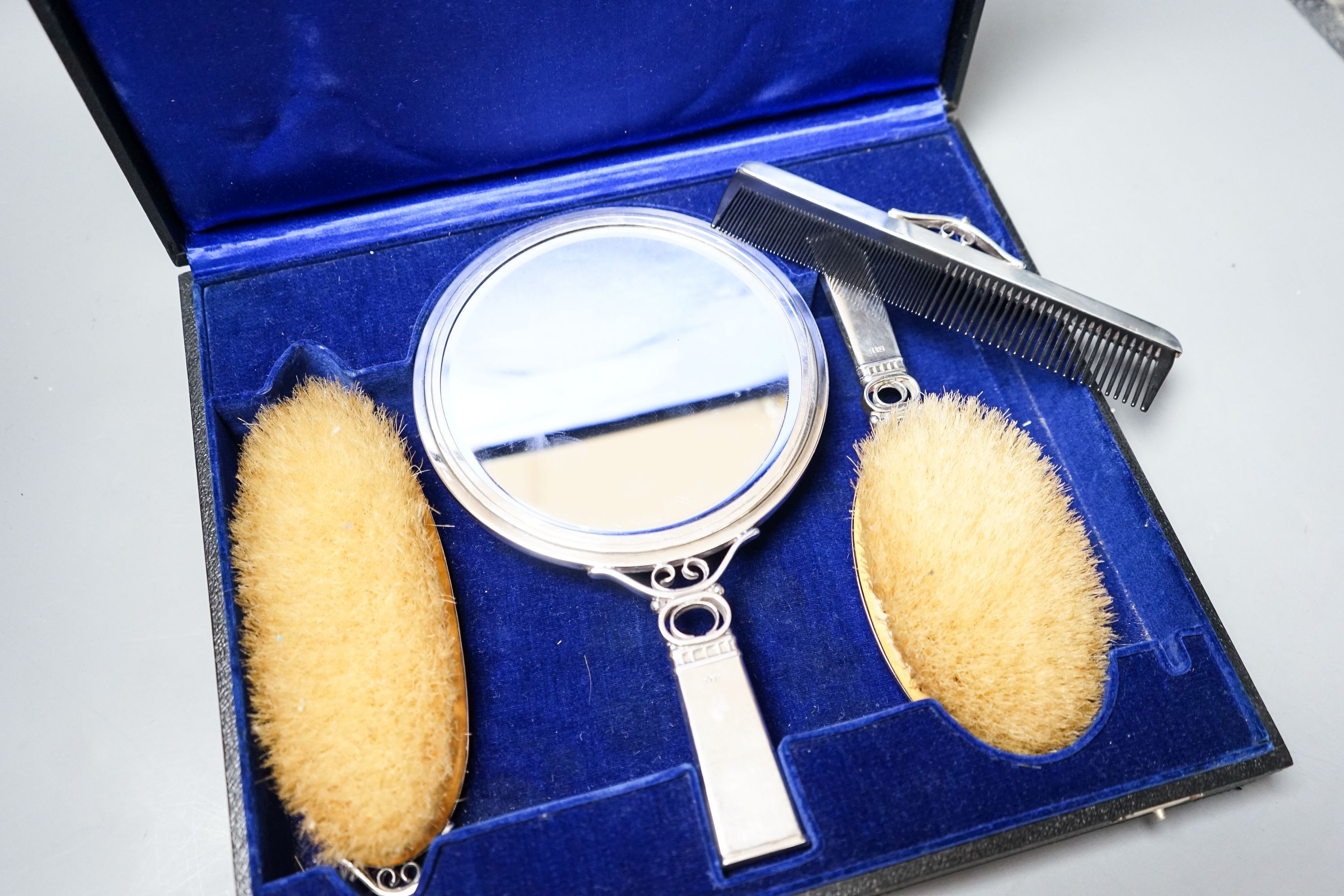 A cased stylish continental 830S white metal mounted four piece mirror, brush and comb set, mirror 24.5cm.